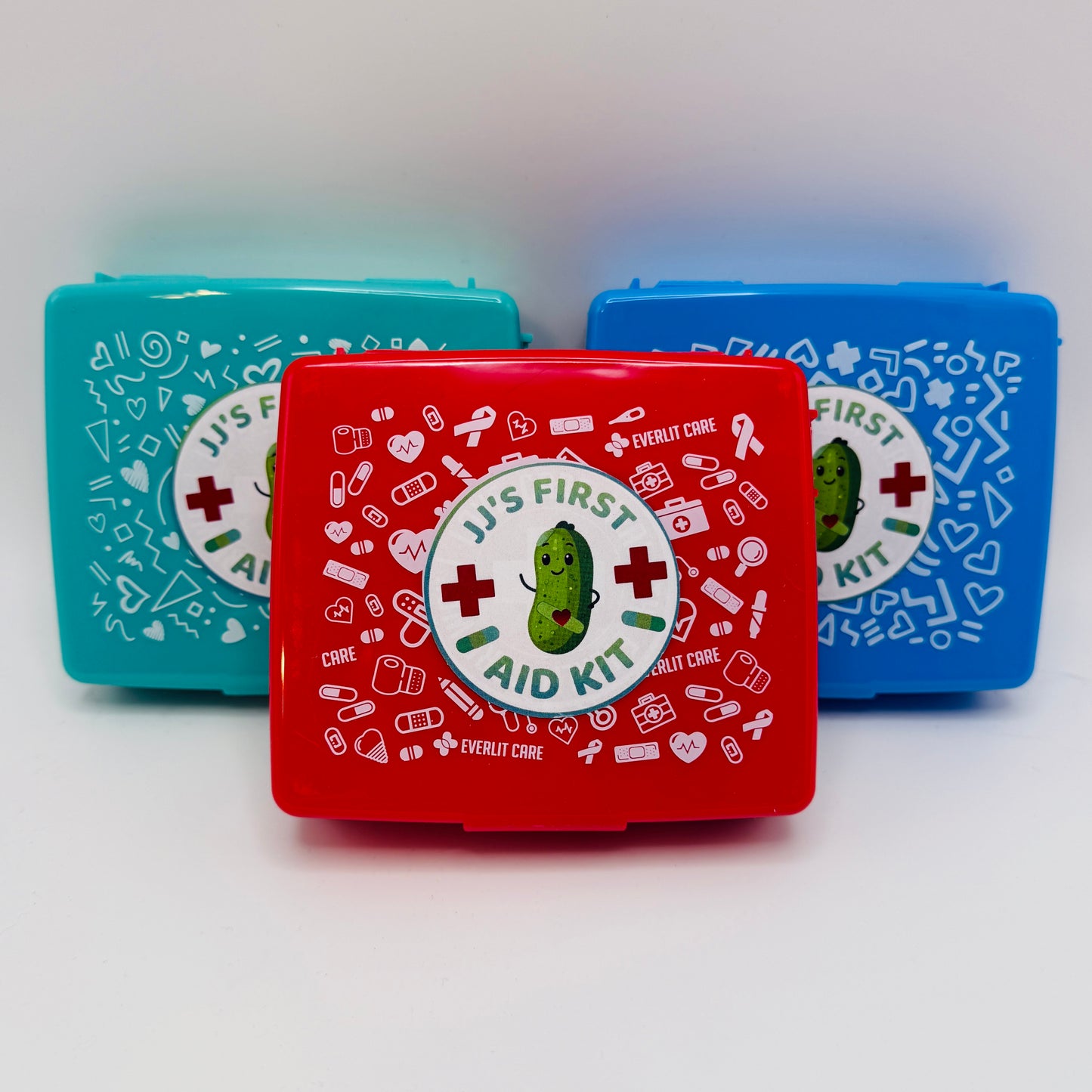 A curated gift box set featuring a copy of the book 'Hot Pickle' by JJ Knight, a red 'First Aid Kit' box, and matching stickers.
