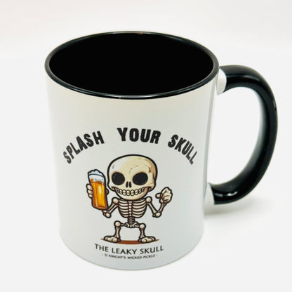 Mug with a skeleton design and text 'Splash Your Skull' on a white background