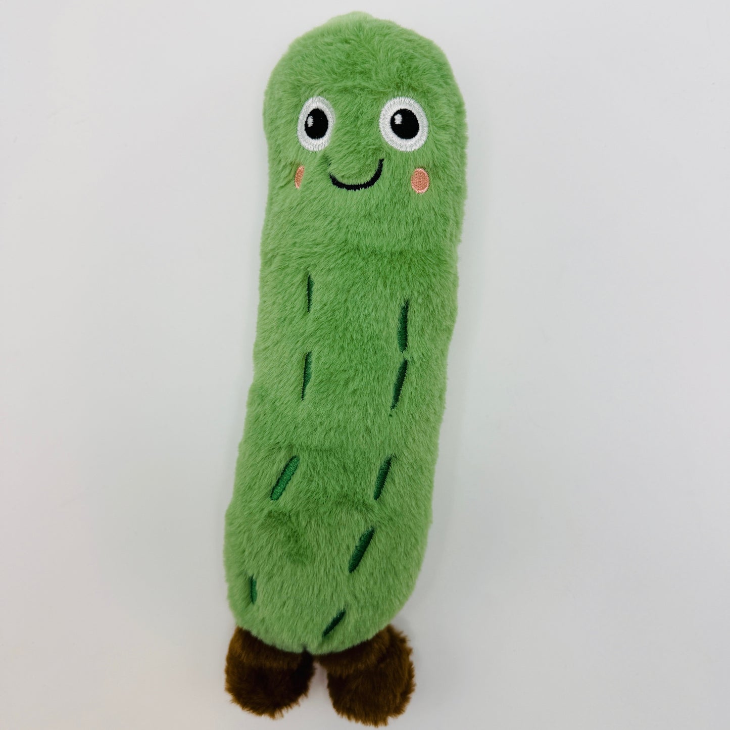 Green plush toy resembling a pickle on a white background